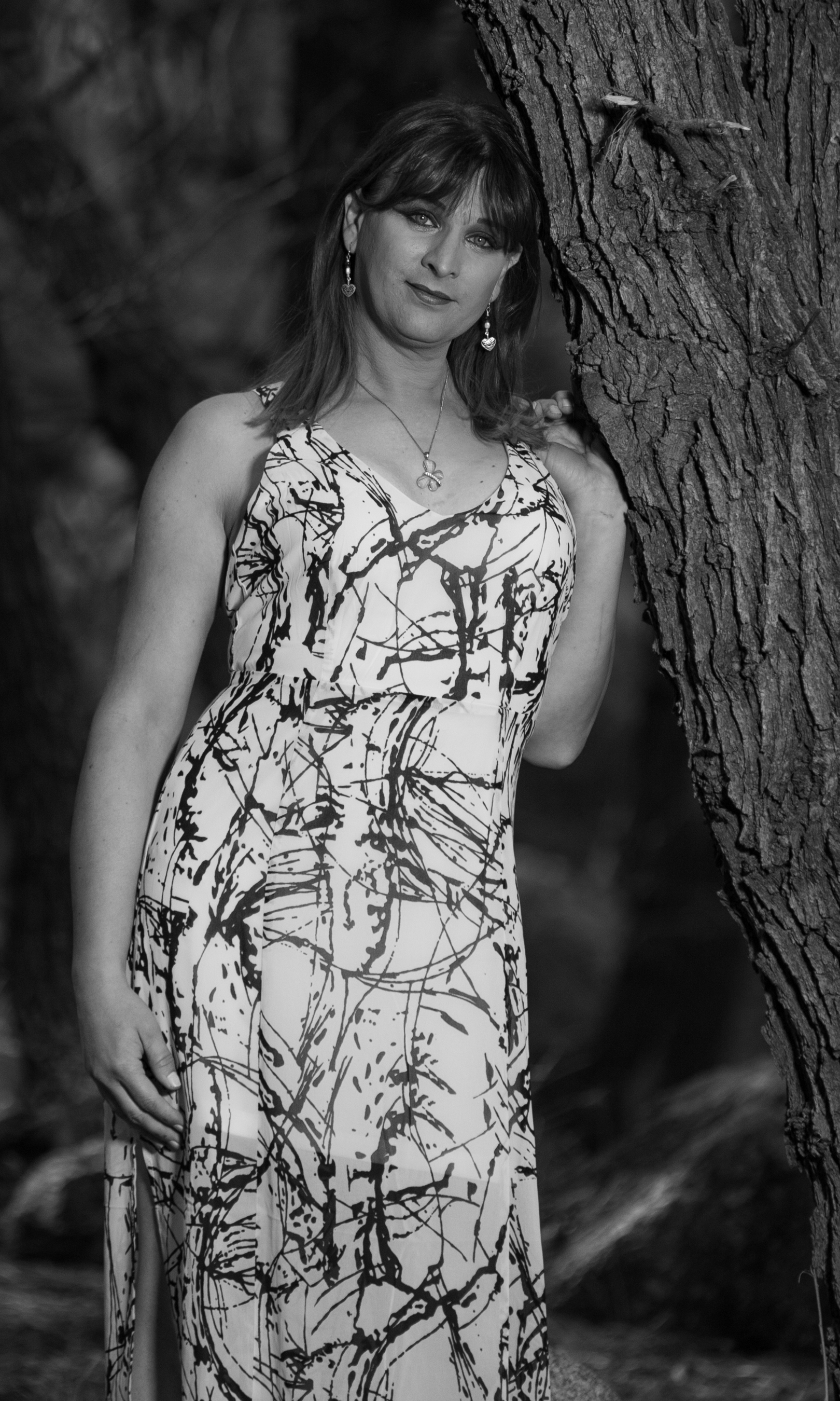 Black & White photo of Sarah Flowers leaning against a tree